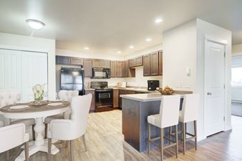 a kitchen and dining room with white chairs and a table